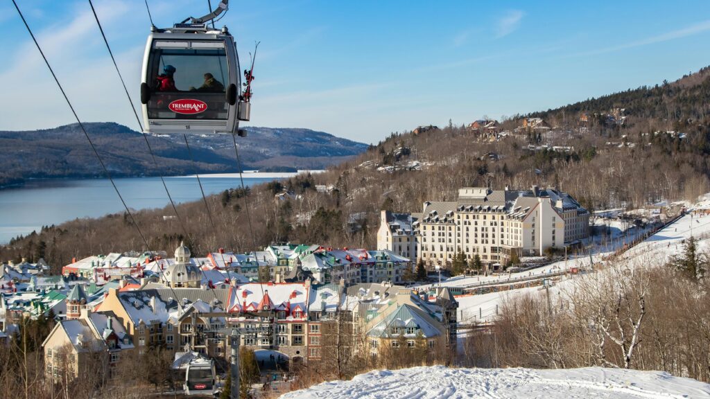 Breathtaking aerial shot of Mont-Tremblant village with a cable car, surrounded by snowy mountains