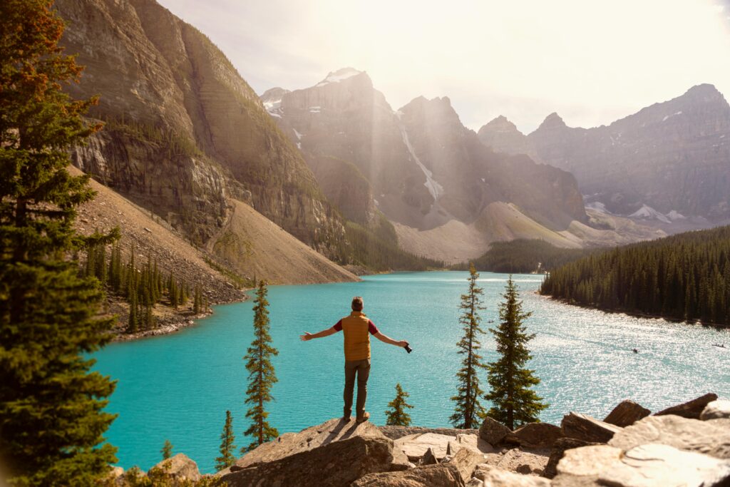 Capture the breathtaking view of Moraine Lake with a solo adventurer under the summer sun.